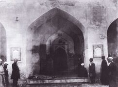 The altar of Kufa Mosque where Imam 'Ali (a) was struck with a sword by Ibn Muljam al-Muradi on the morning of Ramadan 19, 40 (January 29, 661). The photo is taken by Aqa Rida Khan 'Akkasbashi when Mesopotamia was under the ruling of Ottoman Empire. On the left bottom of the picture a man is shown who has invoked to Imam 'Ali (a) to heal his illness. (Featured in July 6, 2015)